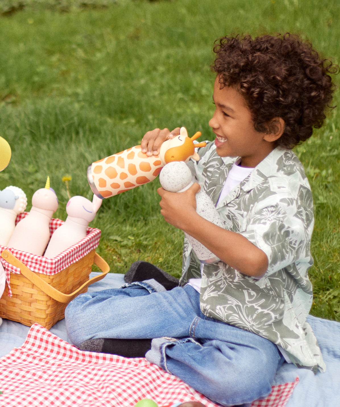 Niño bebiendo de la botella térmica Asobu Bestie Jirafa, mostrando su facilidad de uso.