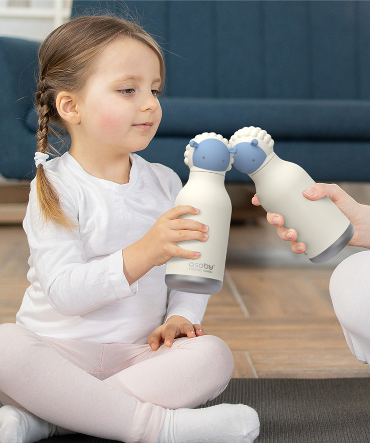Niña sosteniendo y jugando con su botella Asobu Bestie Oveja de 460ml.