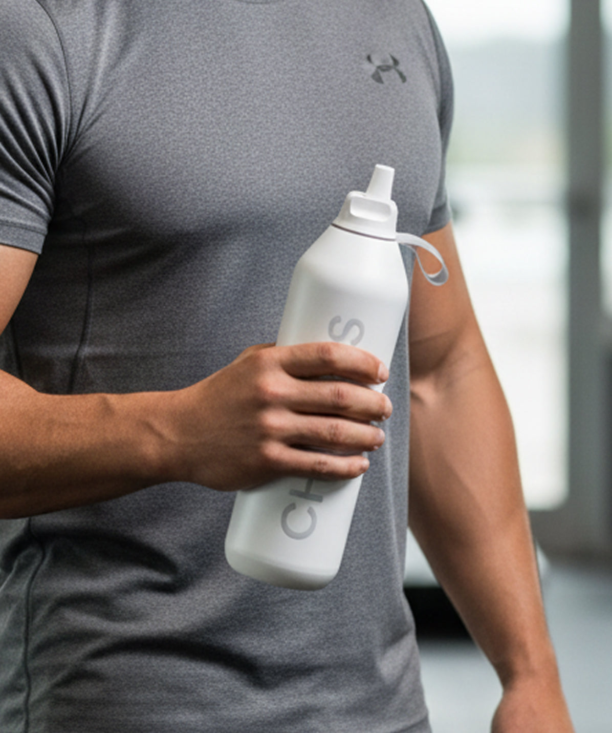 Botella Chilly's Serie 2 Flip Gris Granito 1000ml (1L). Botella termo con tapa deportiva (Flip) para gimnasio. Hombre usando su Chilly's de acero inoxidable con aislamiento 24h.