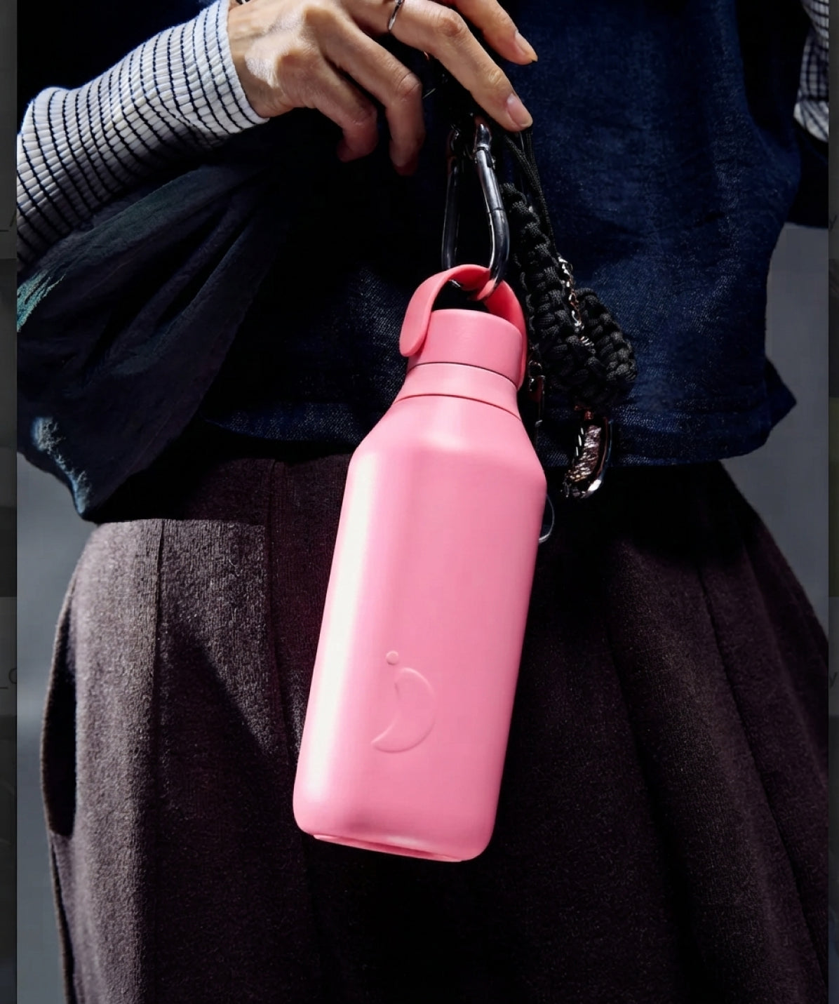 Botella Chilly's Serie 3 Rosa Lotus 500ml colgando de un bolso, uso lifestyle diario.