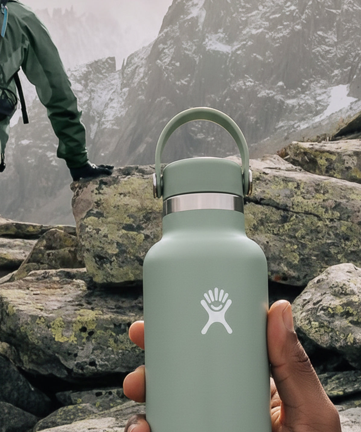 Botella Hydro Flask Standard Flex Cap Agave 21oz en mano, en un entorno de montaña. Perfecta para excursiones.