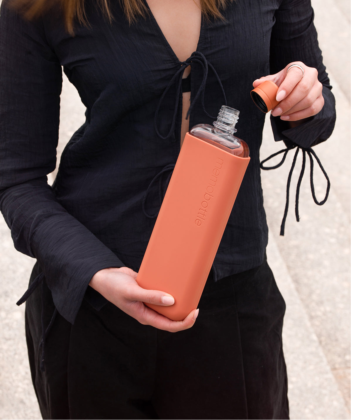Botella Memobottle Slim terracota (450ml) en uso, un accesorio de estilo plano que cabe donde otras botellas no pueden.