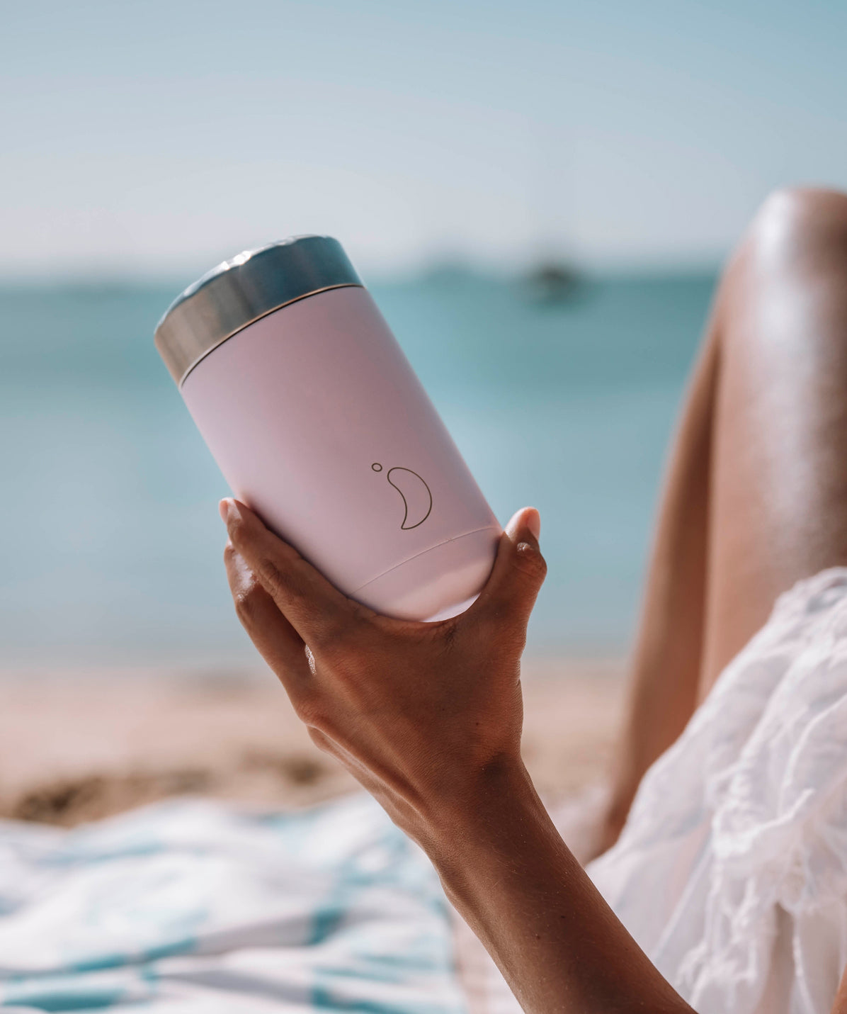 Termo Chilly's rosa de 500ml usado para llevar snacks frescos o alimentos fríos durante un día de playa.