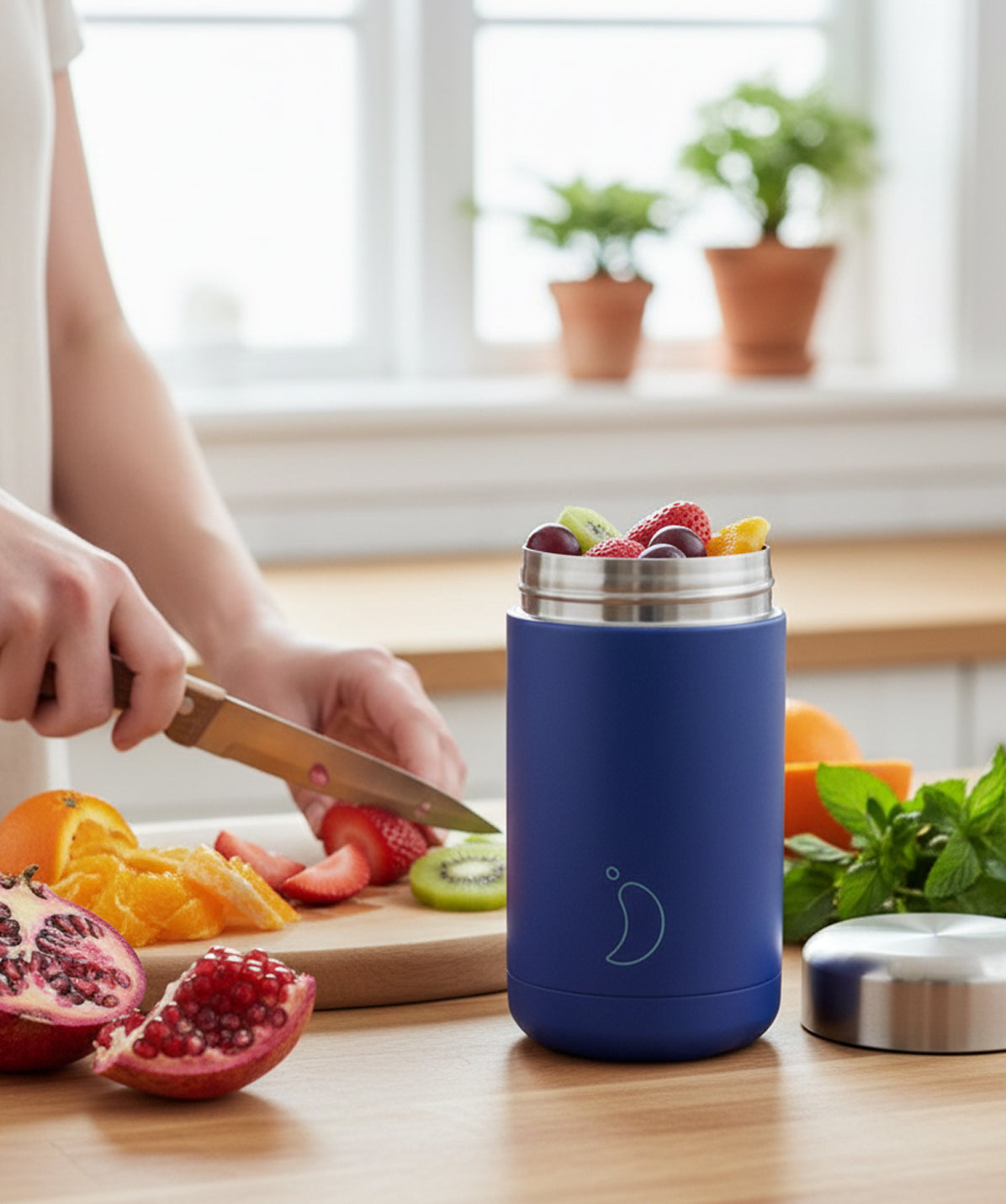 Termo de sólidos Chilly's Mate Azul 500ml sobre una mesa de madera con fruta. Termo de comida reutilizable para llevar un almuerzo saludable.