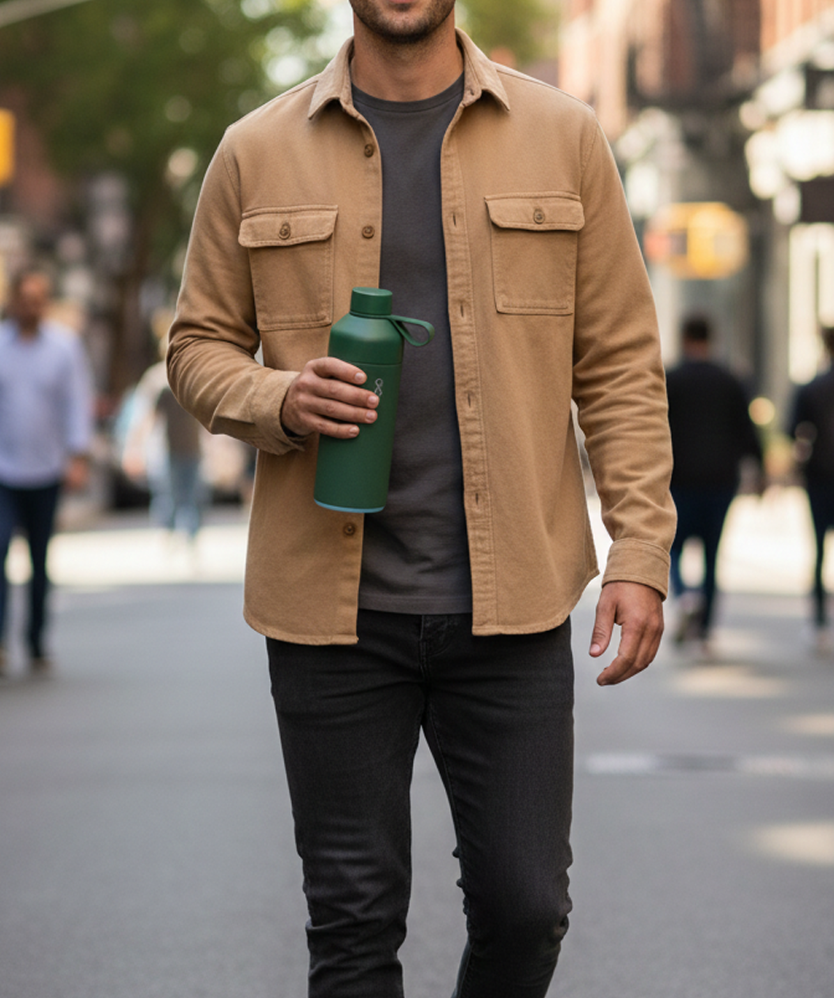 Chico caminando con la Botella Ocean Bottle Verde bosque 500ml en mano. Botella reutilizable para el día a día.